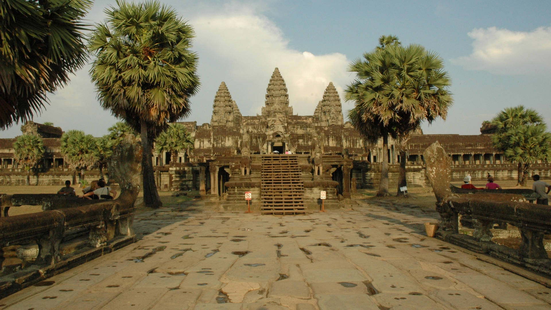 Angkor Wat With Trees By The Road Background