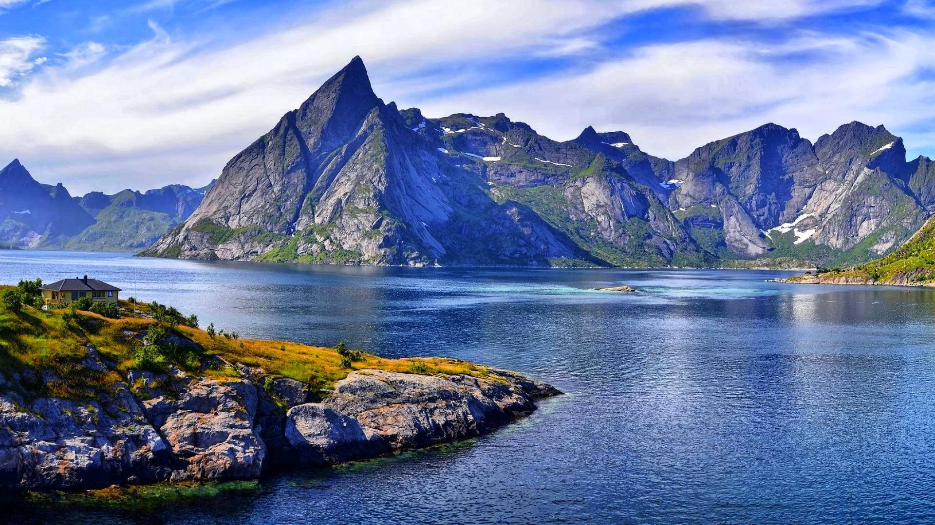 Angular Rocky Mountains Over Huge Body Of Water Background