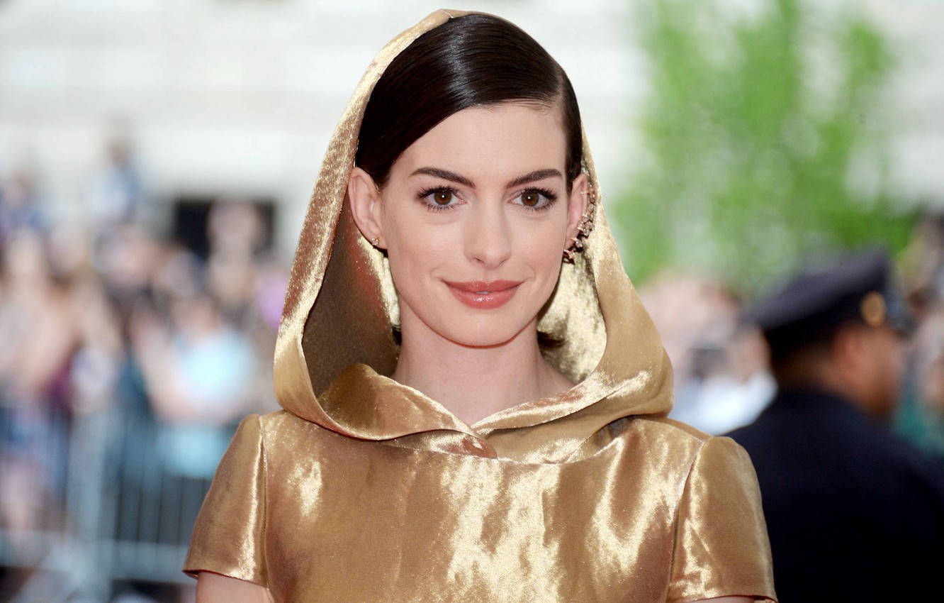 Anne Hathaway In A Glamorous Golden Robe Background