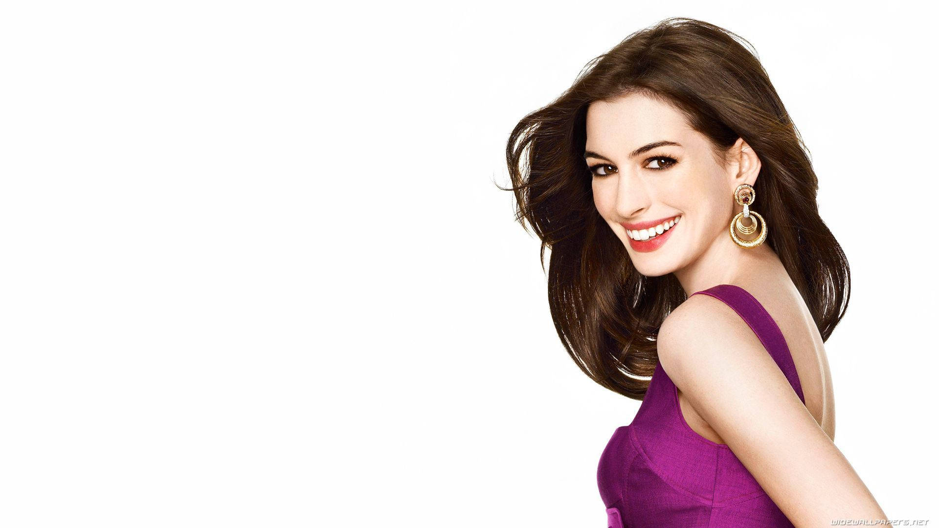 Anne Hathaway In A Stunning Purple Dress Smiling For The Camera Background