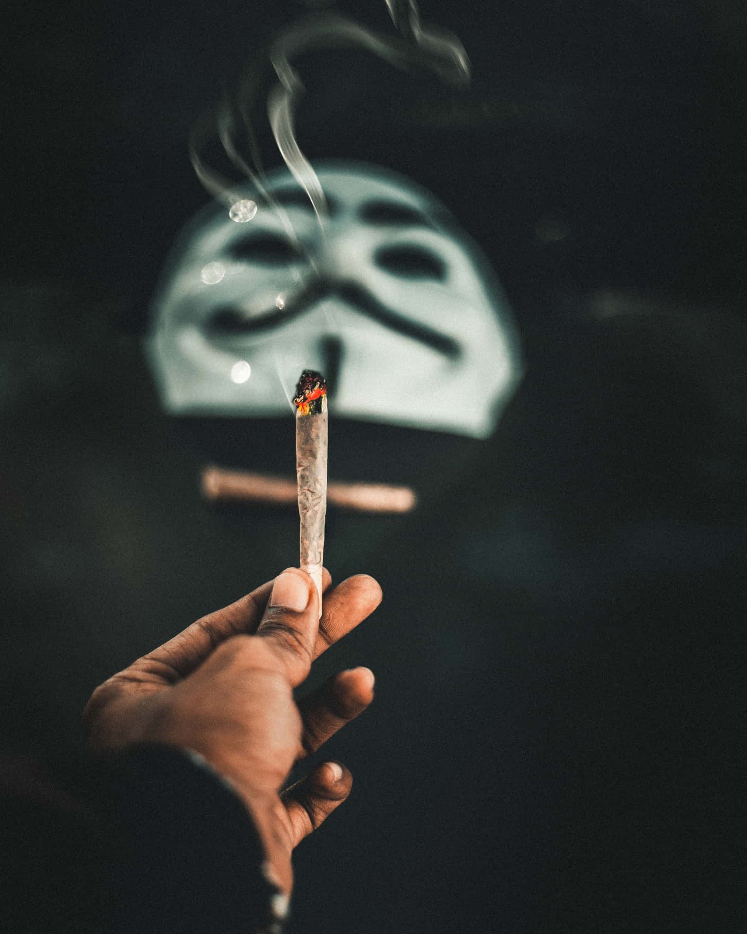 Anonymity And Rebellion: A Masked Man Smoking A Joint Background