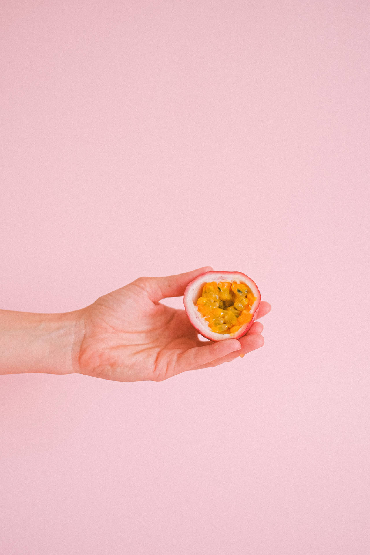 Anonymous Hand Showing Sliced Passion Fruit Background