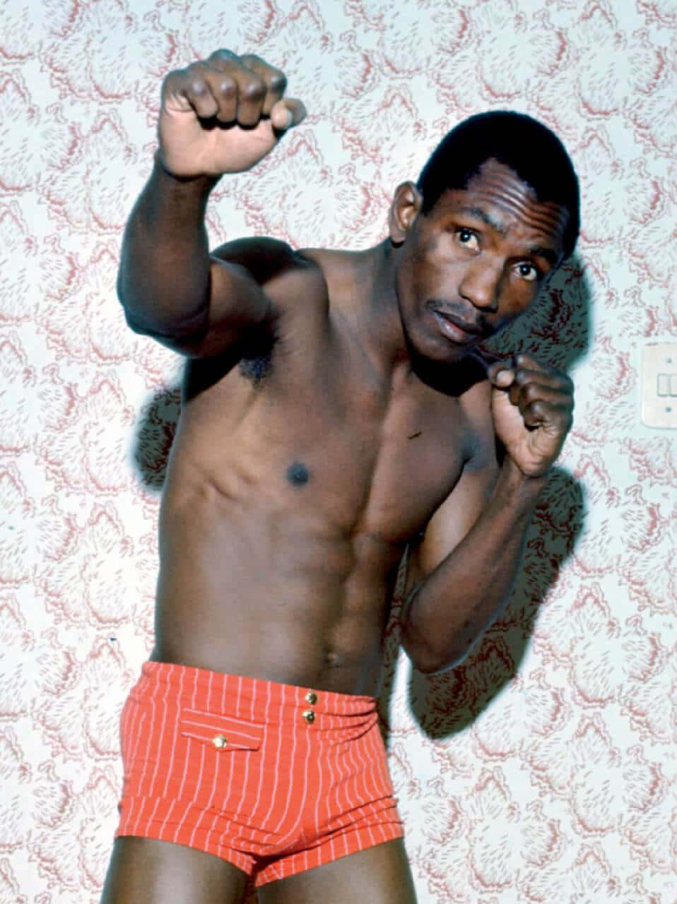 Antonio Cervantes Punching Pose In Orange Striped Shorts Background