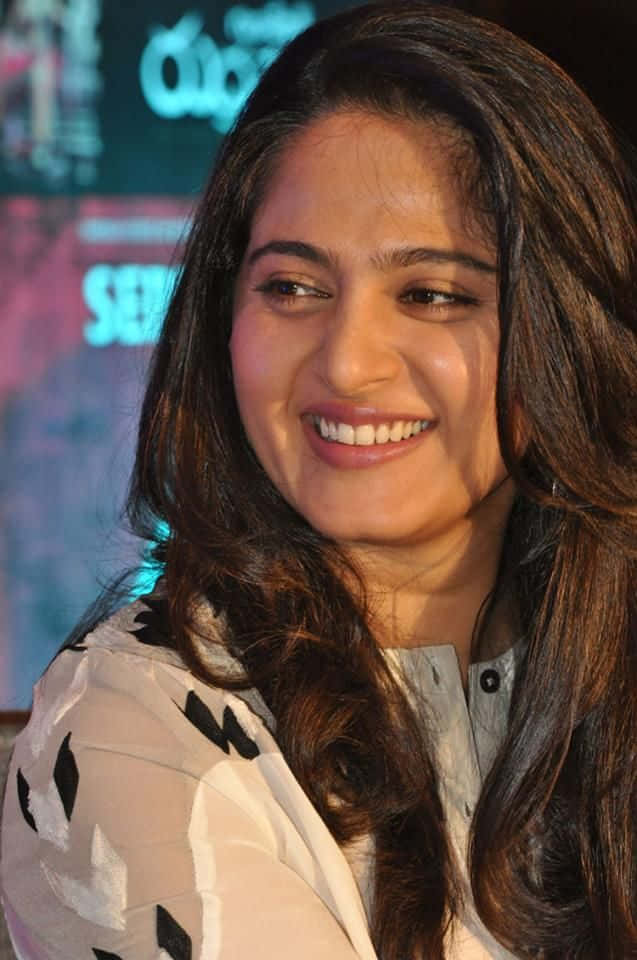 Anushka Shetty Smiling Event Appearance Background