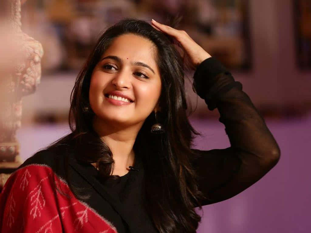 Anushka Shetty Smilingin Black Attire Background