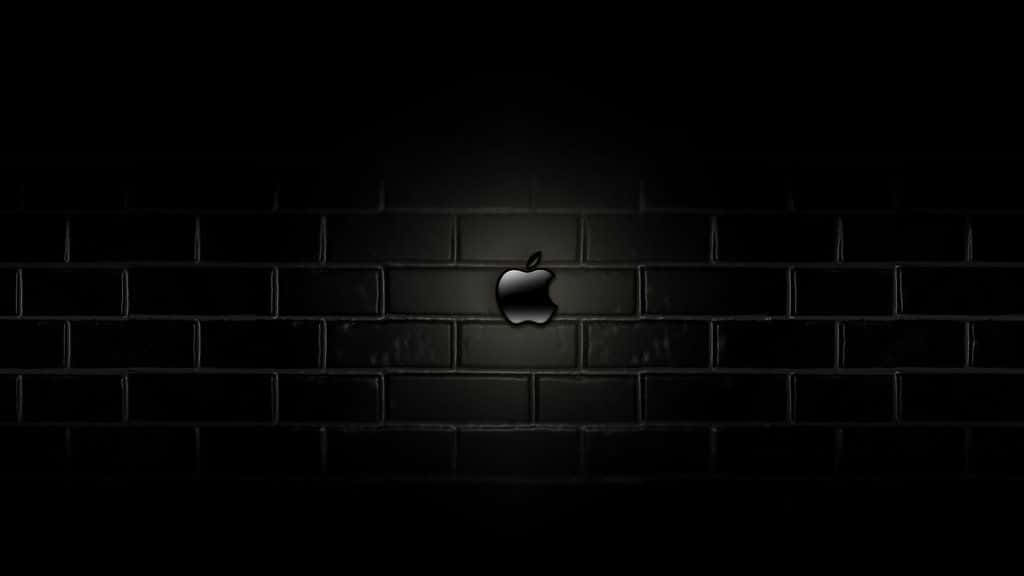 Apple Logo On A Brick Wall In The Dark Background