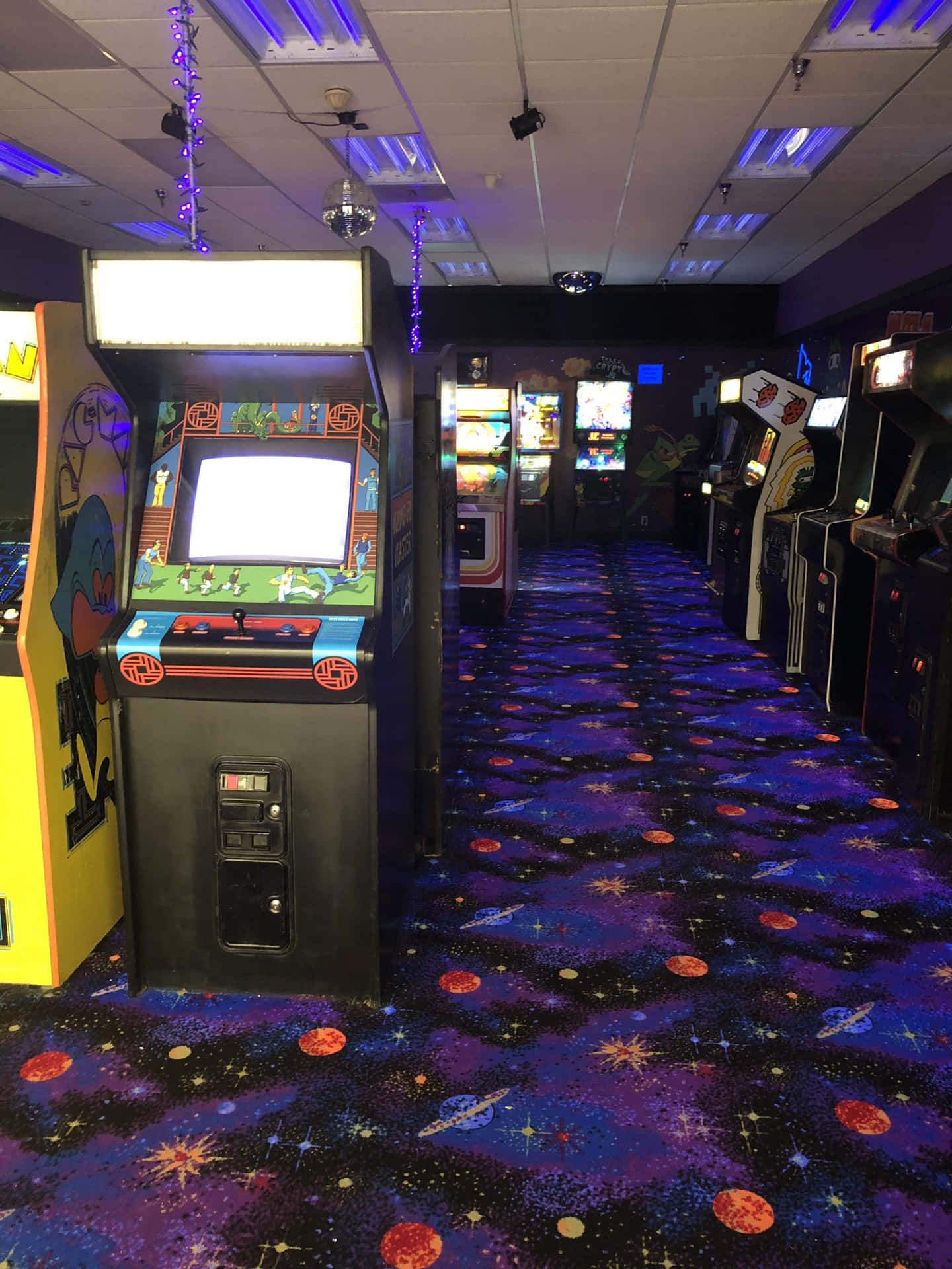 Arcade Machines In A Room With Purple Carpet Background