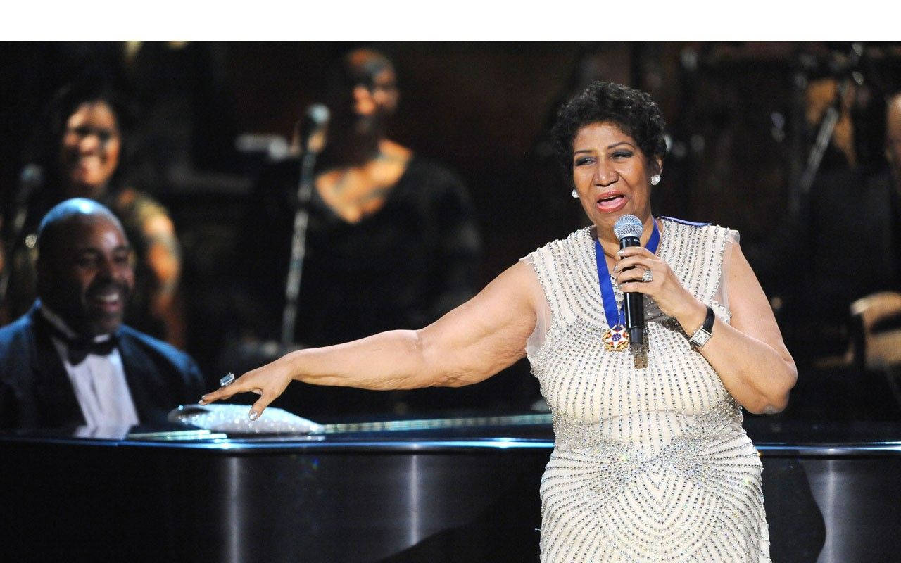 Aretha Franklin In Front Of A Piano Background