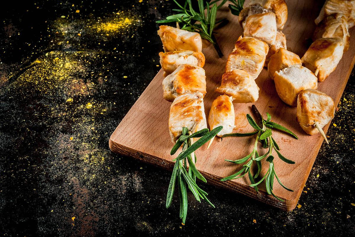 Aromatic Rosemary With Succulent Kebabs On Chopping Board Background