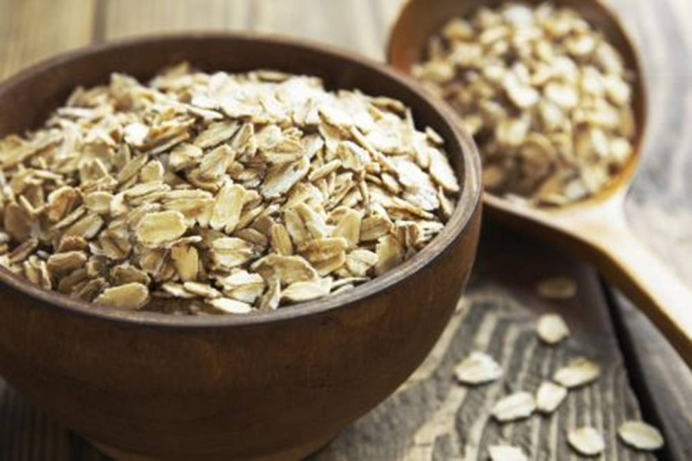 Artisanal Wooden Bowl With Raw Oatmeal Background