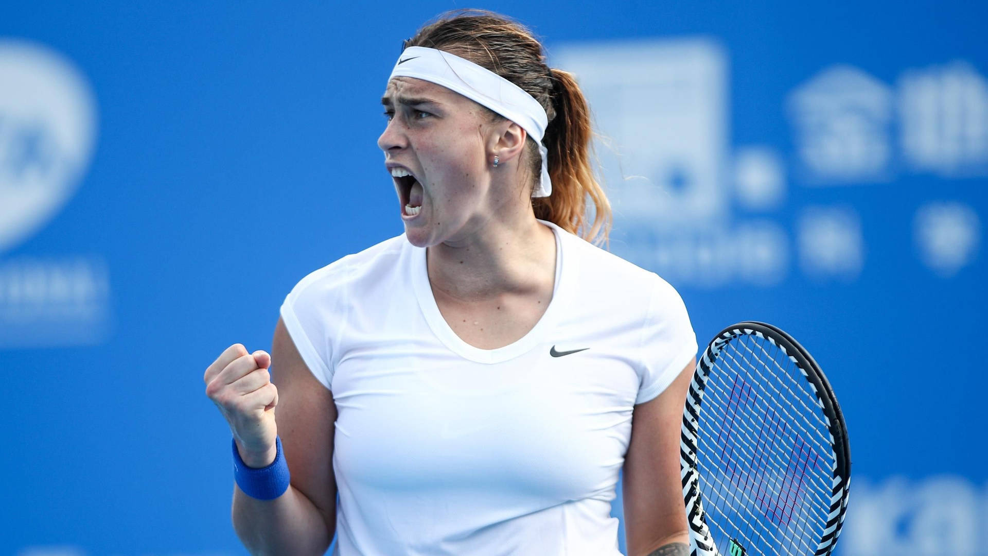 Aryna Sabalenka Expressing Intensity On The Tennis Court Background