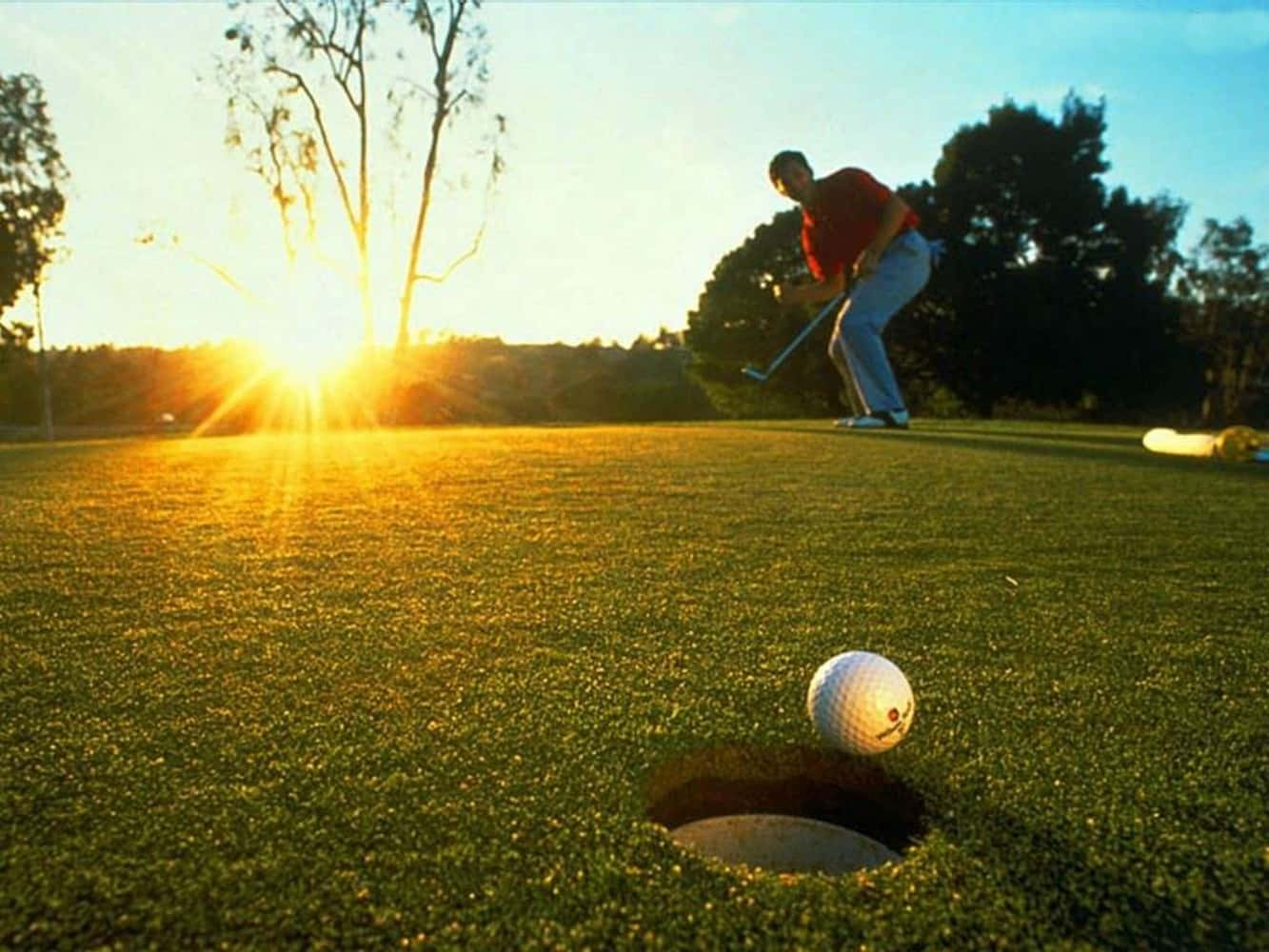 Aspiring Golfer Teeing Off On A Beautiful Sunny Day Background