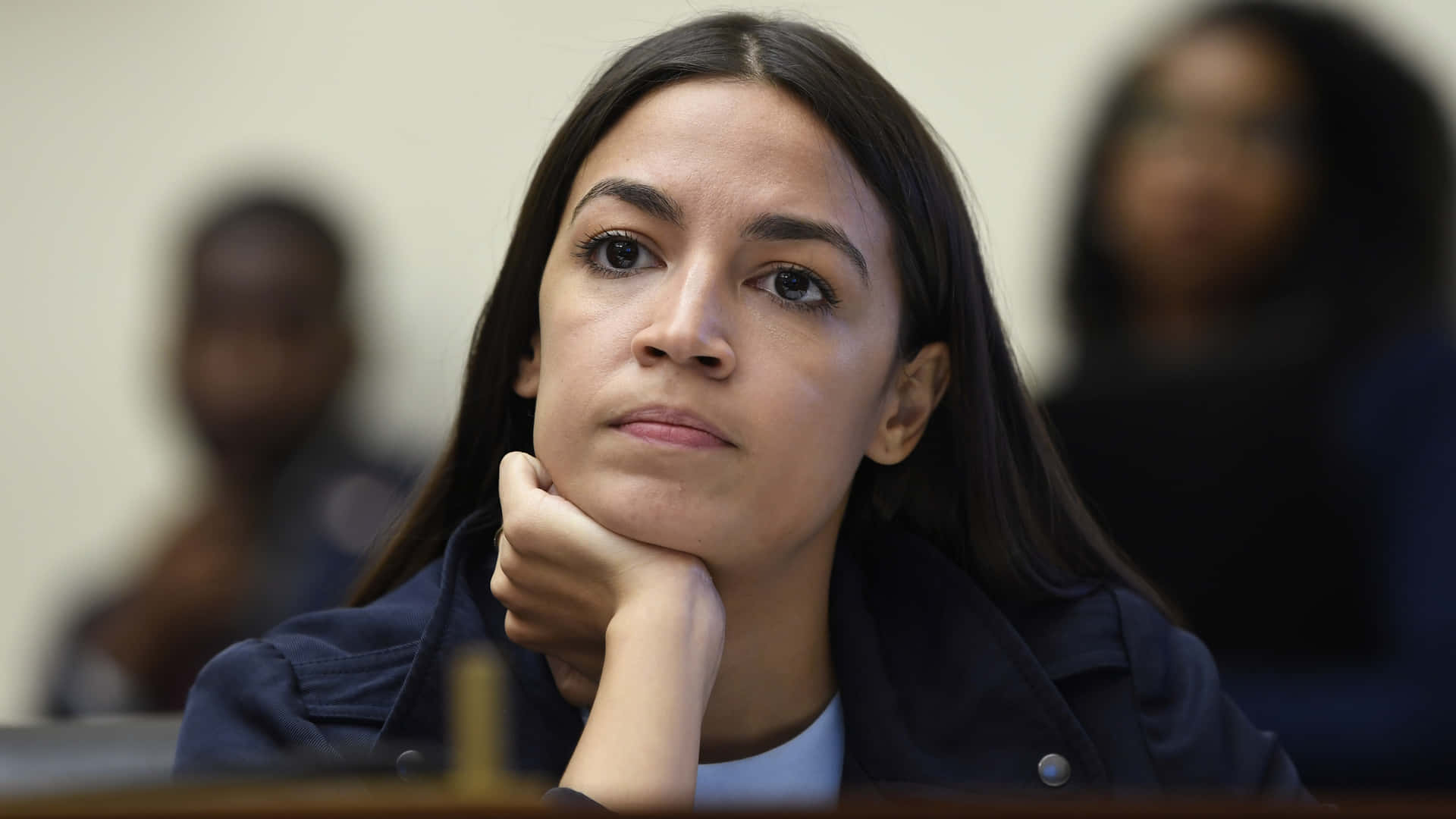 Assertive Alexandria Ocasio-cortez Looking Determined Background