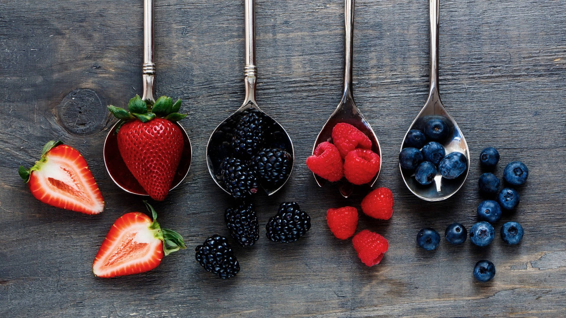 Assorted Berries On Spoons Background