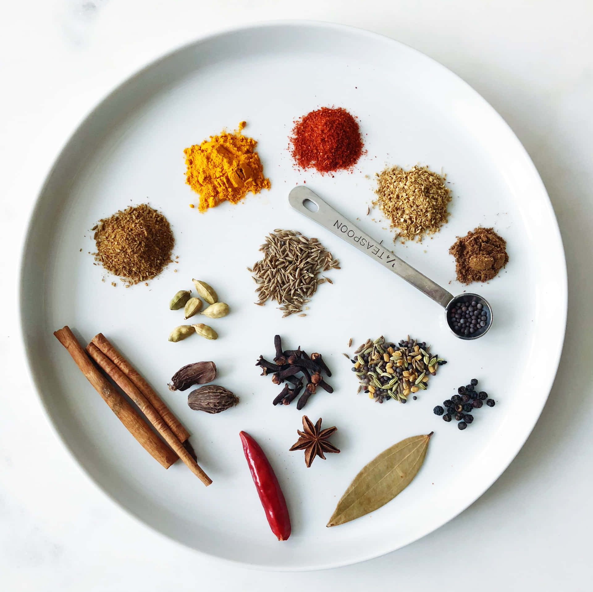 Assortment Of Vibrant Spices On A White Round Plate. Background