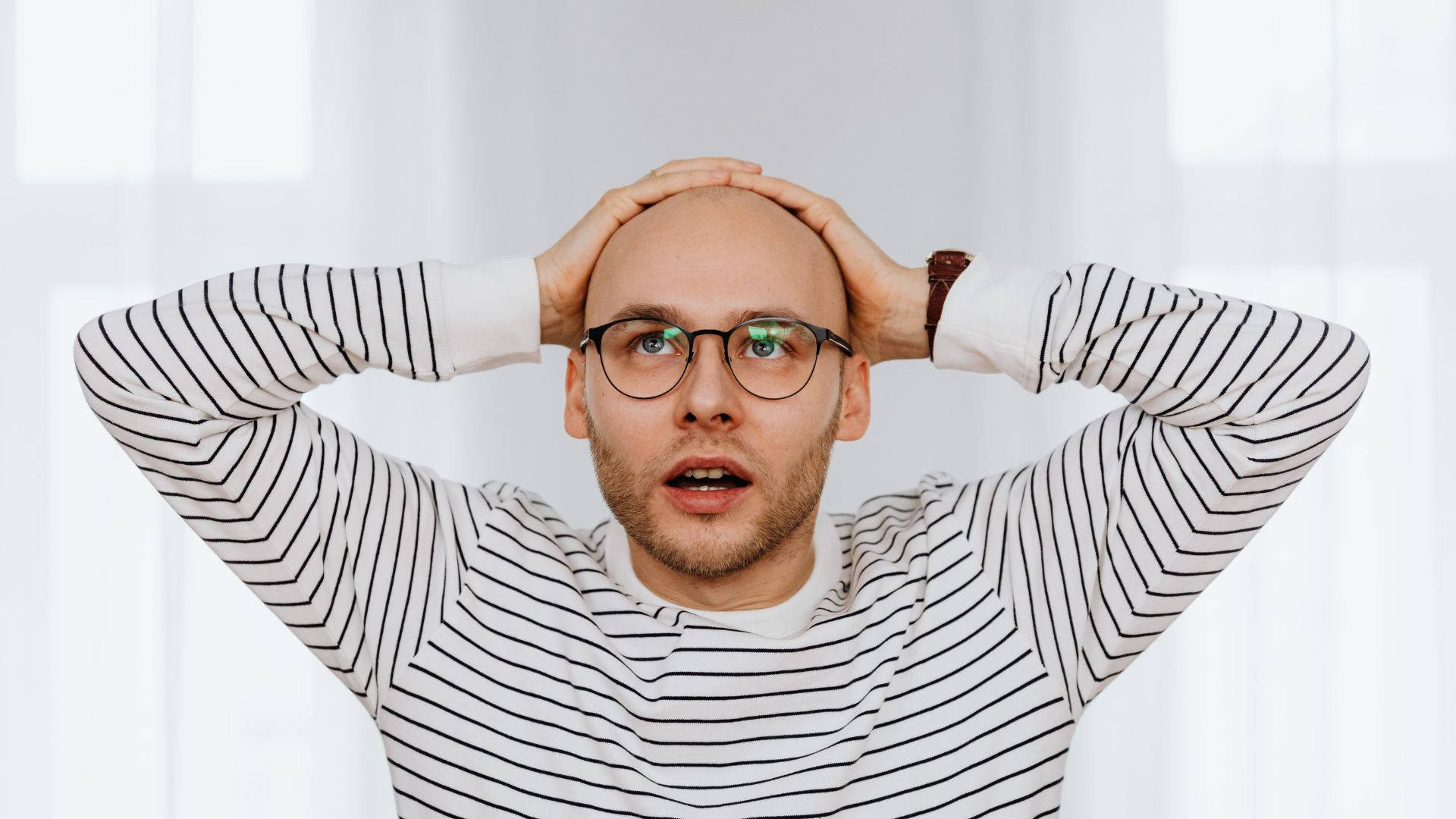 Astonished Bald Man Expressing Disbelief Background