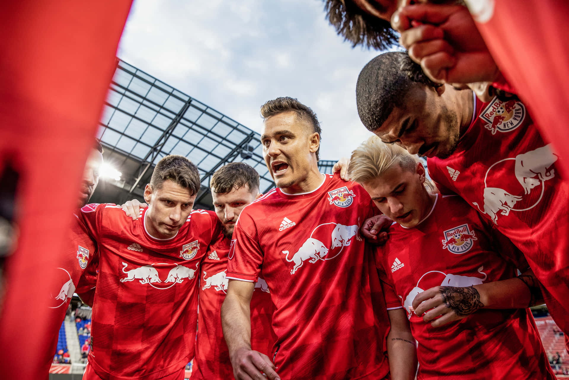 Athlete Aaron Long And Teammates Huddling Together Background