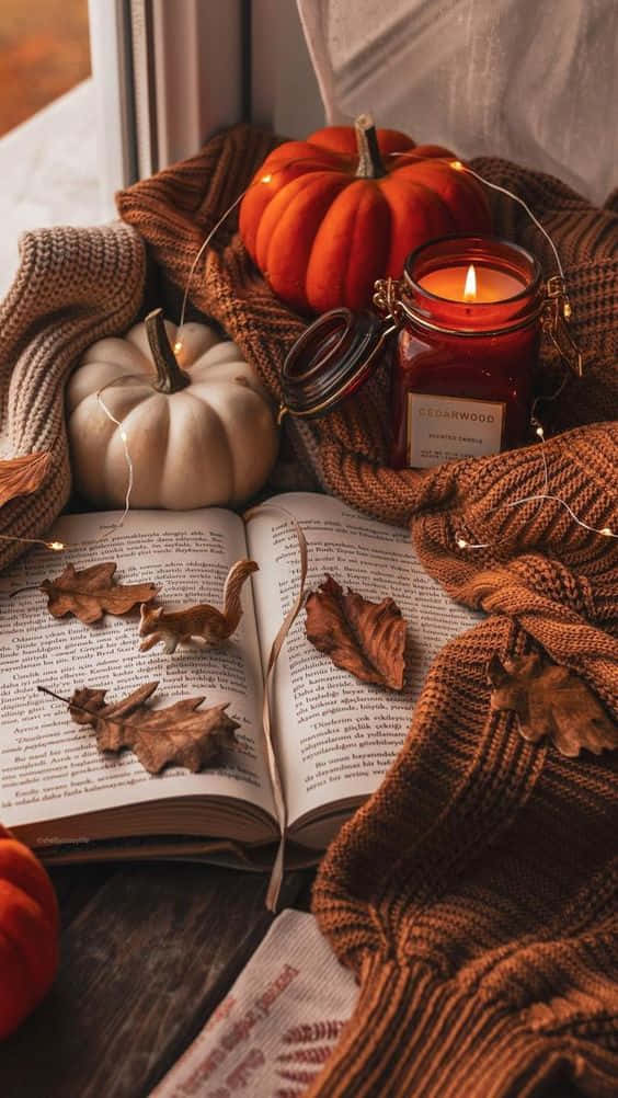 Autumn Leaves, Pumpkins, Candle And Book On A Window Sill