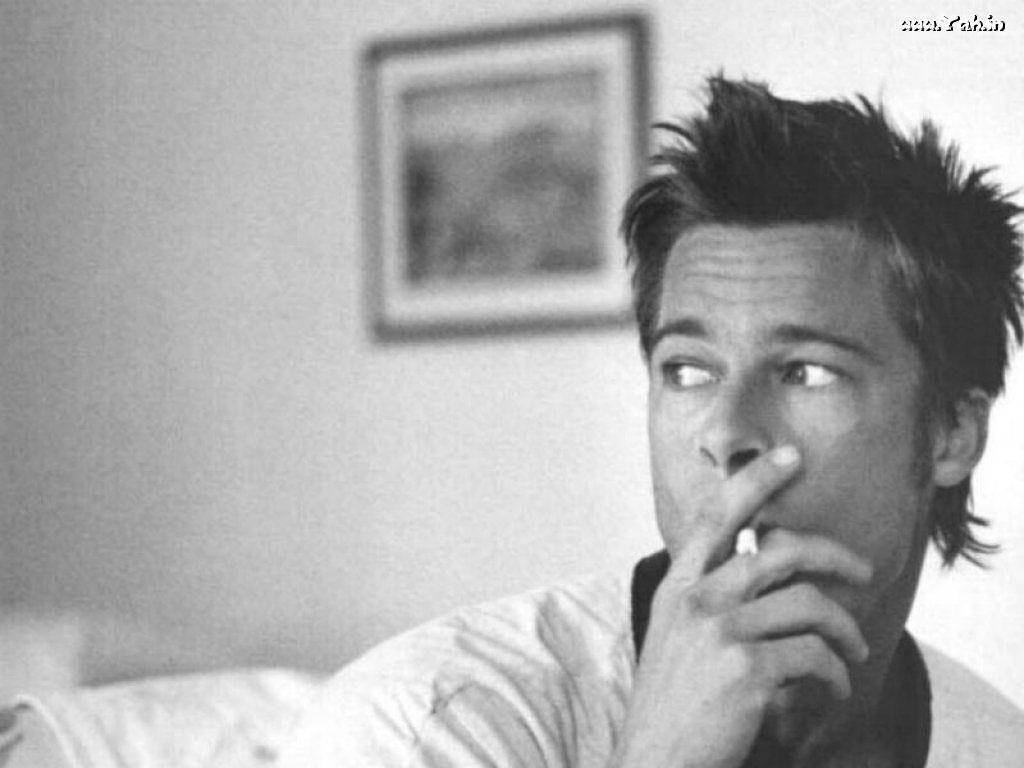 Award-winning Actor Brad Pitt Dressed Up And Smoking In An Intimate Room Background