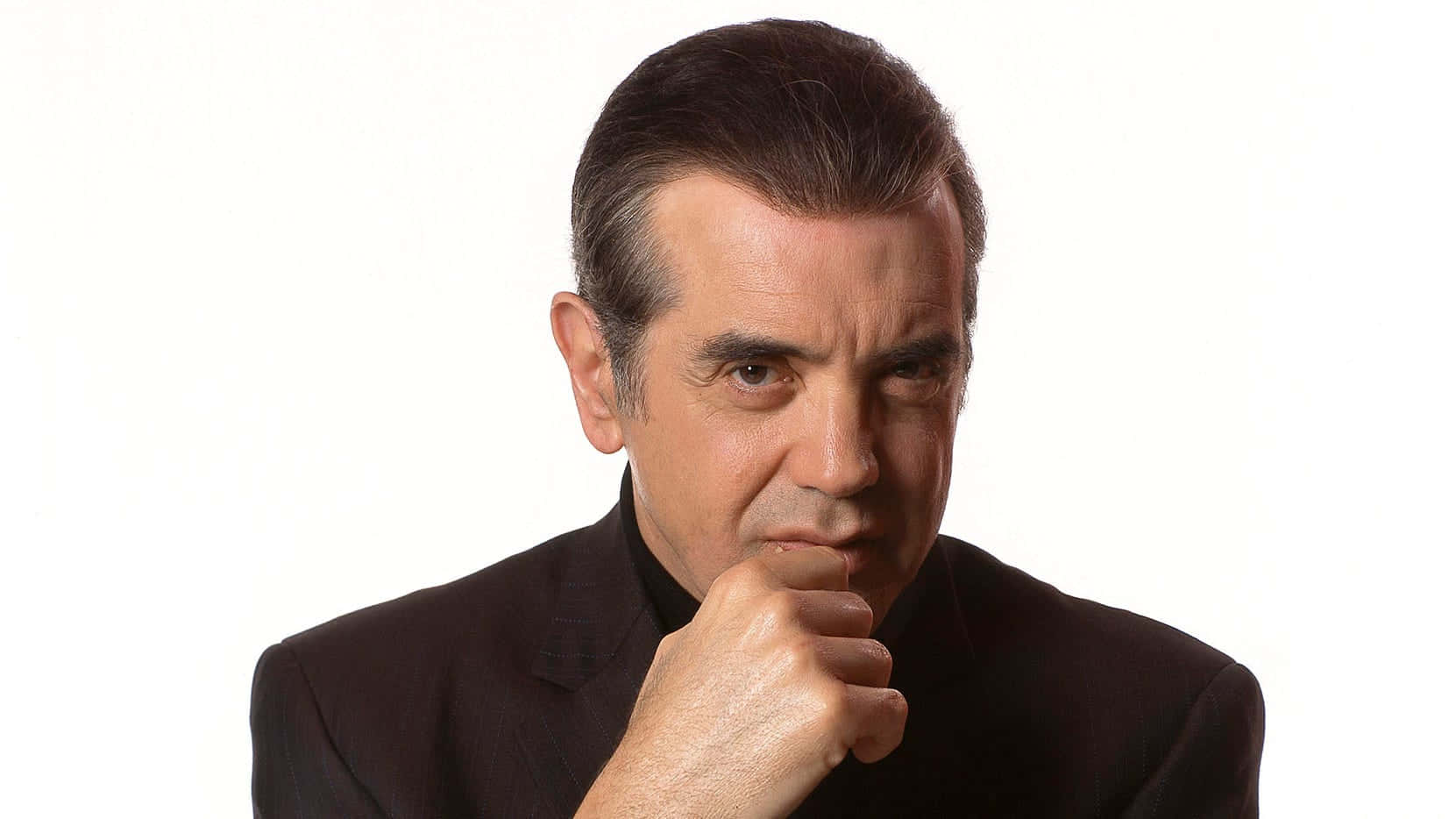 Award-winning Actor Chazz Palminteri Portraying Intensity In A Black And White Wallpaper Design Background