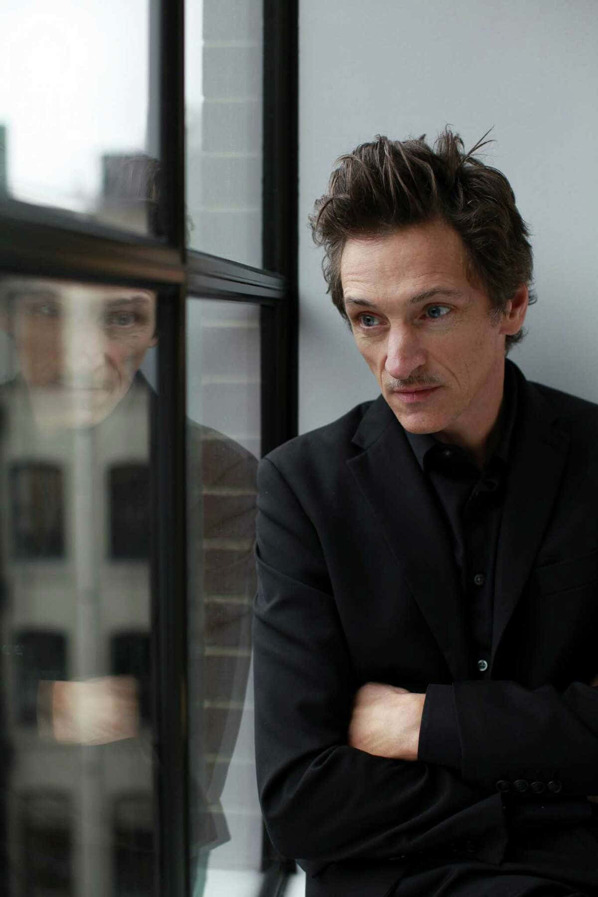 Award-winning Actor John Hawkes Posing For The Camera. Background