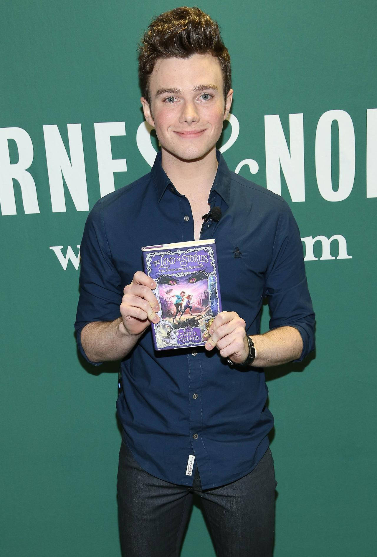 Award-winning Author Chris Colfer Posing With His Best-selling Book 'the Land Of Stories'. Background