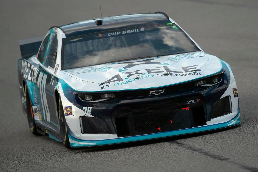 B.j. Mcleod Behind The Wheel Of His Light Blue Nascar Race Car. Background