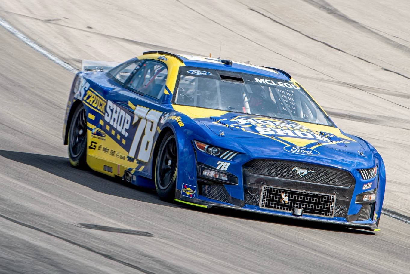 B.j. Mcleod Driving His Blue And Yellow Racing Car Background