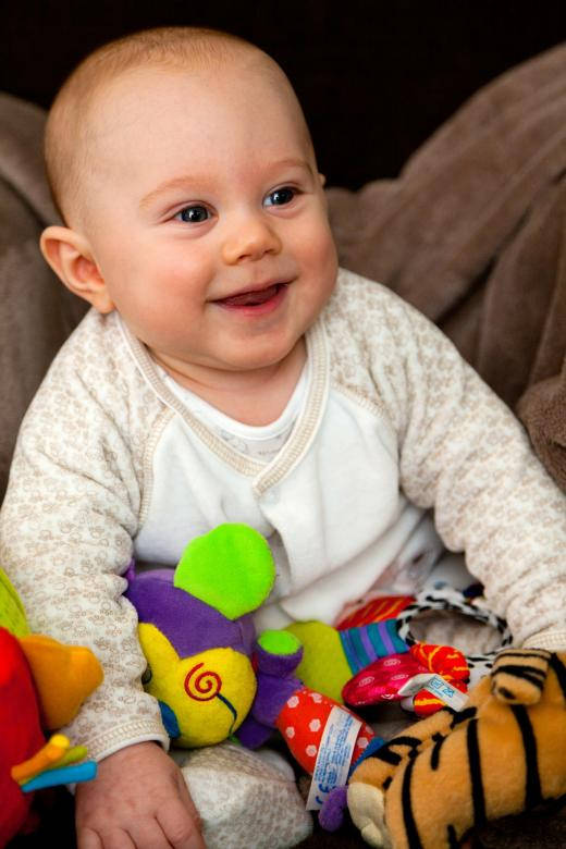 Baby Boy Smiling With Toys Background