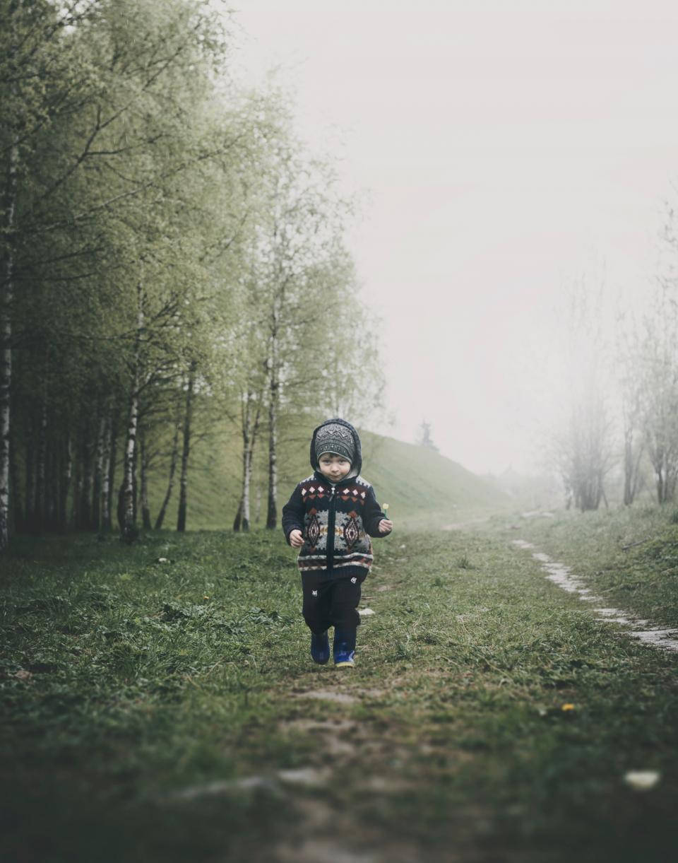 Baby Boy Walking On Grassy Landscape Background
