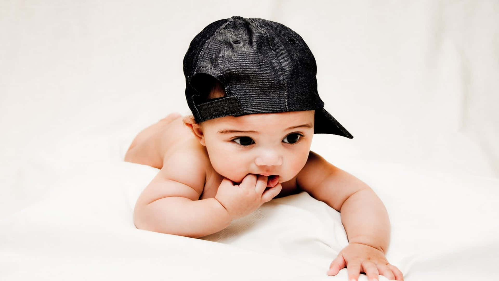 Baby Boy With A Black Cap Background