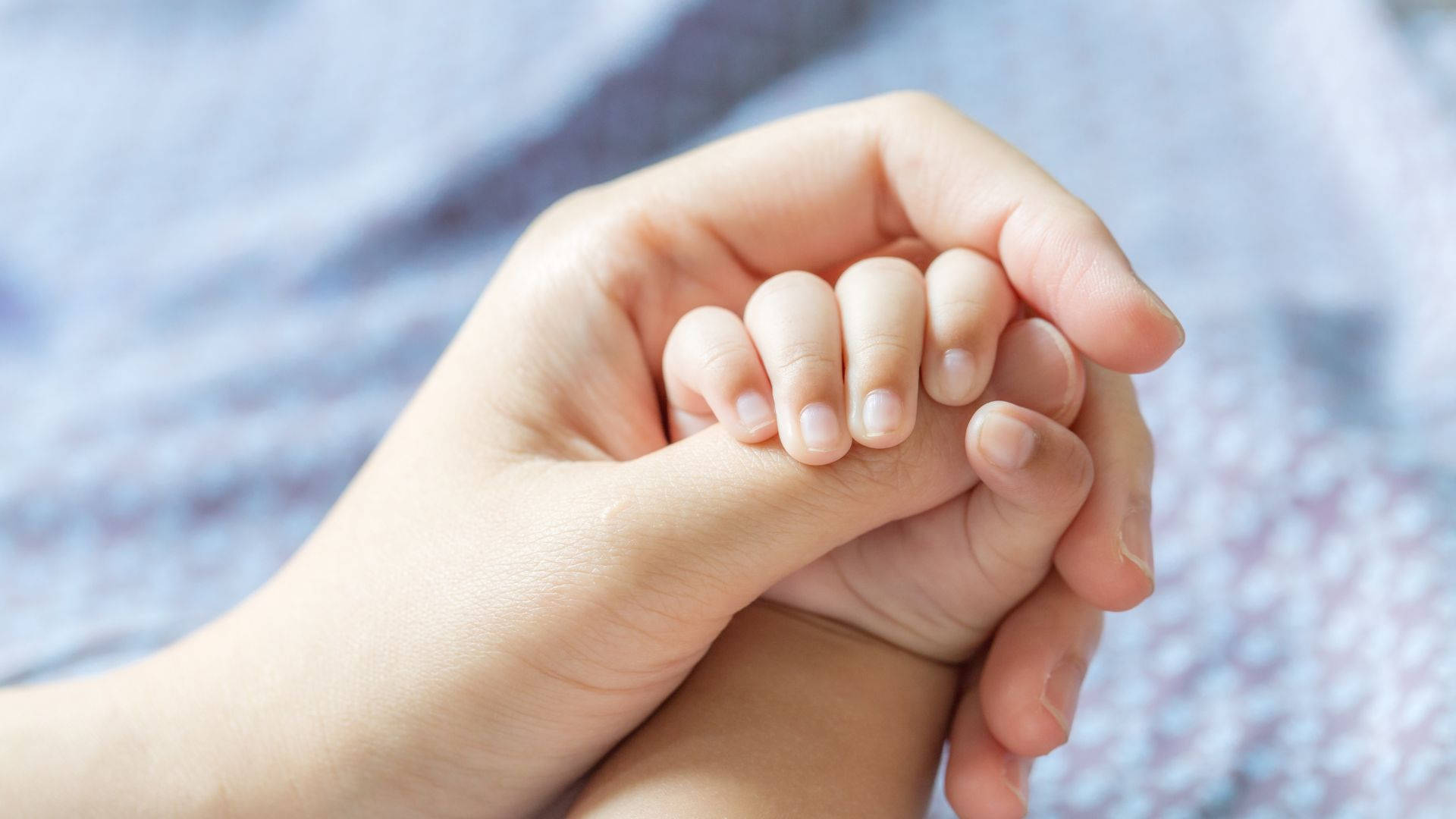 Baby Hand Clutching Mother's Thumb Background