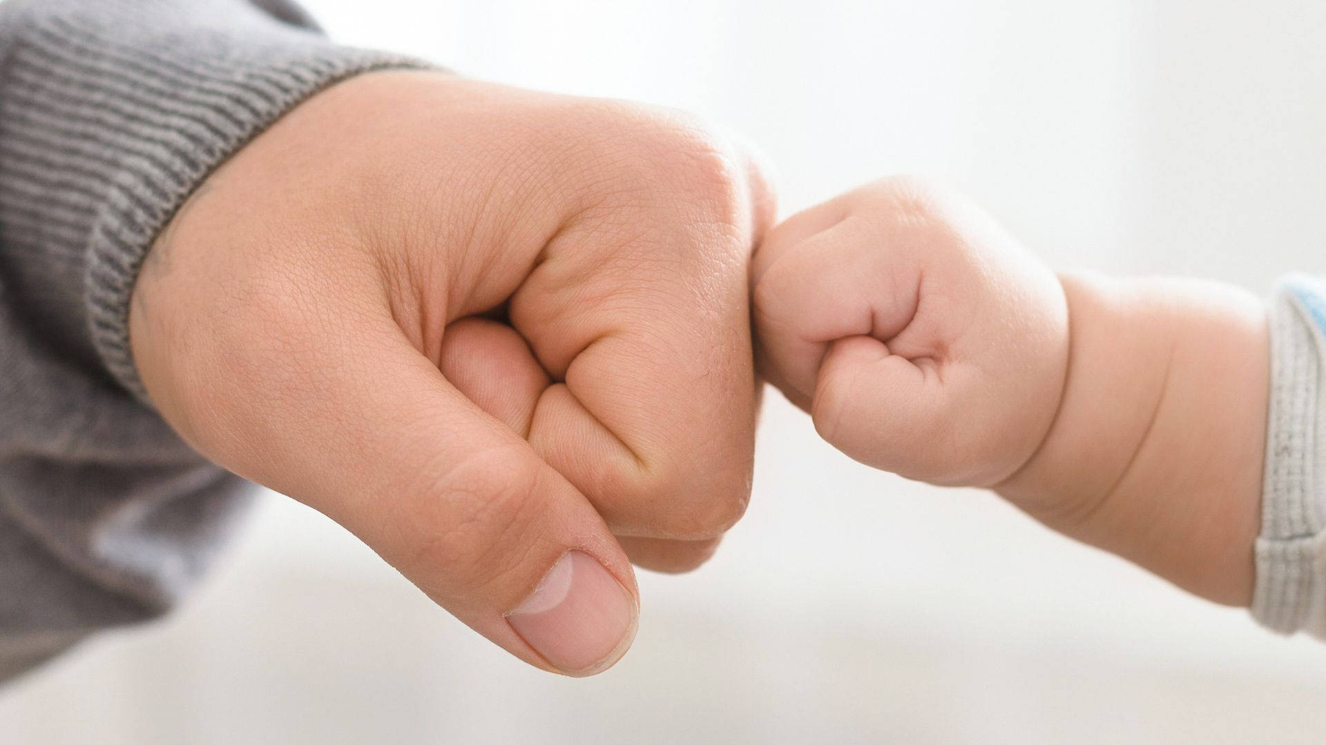 Baby Hand Fist Bumping With Dad Background