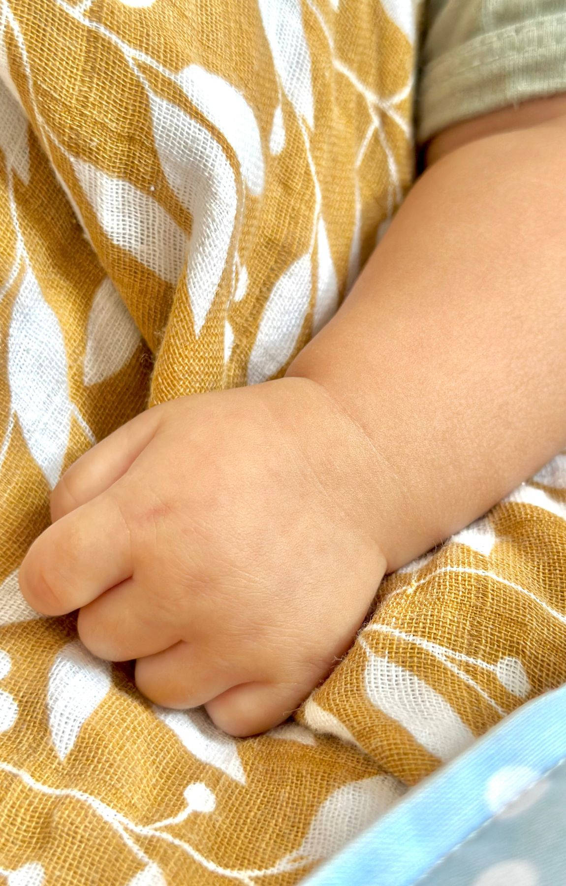 Baby Hand On A Brown Cloth Background