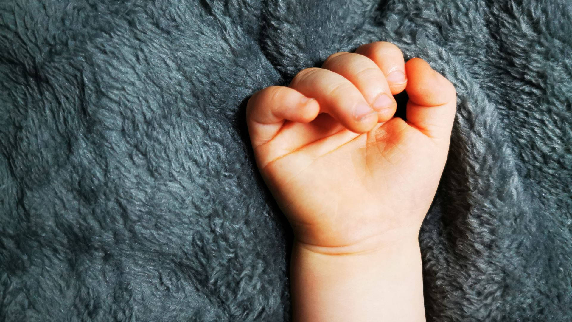 Baby Hand On A Cozy Blanket Background