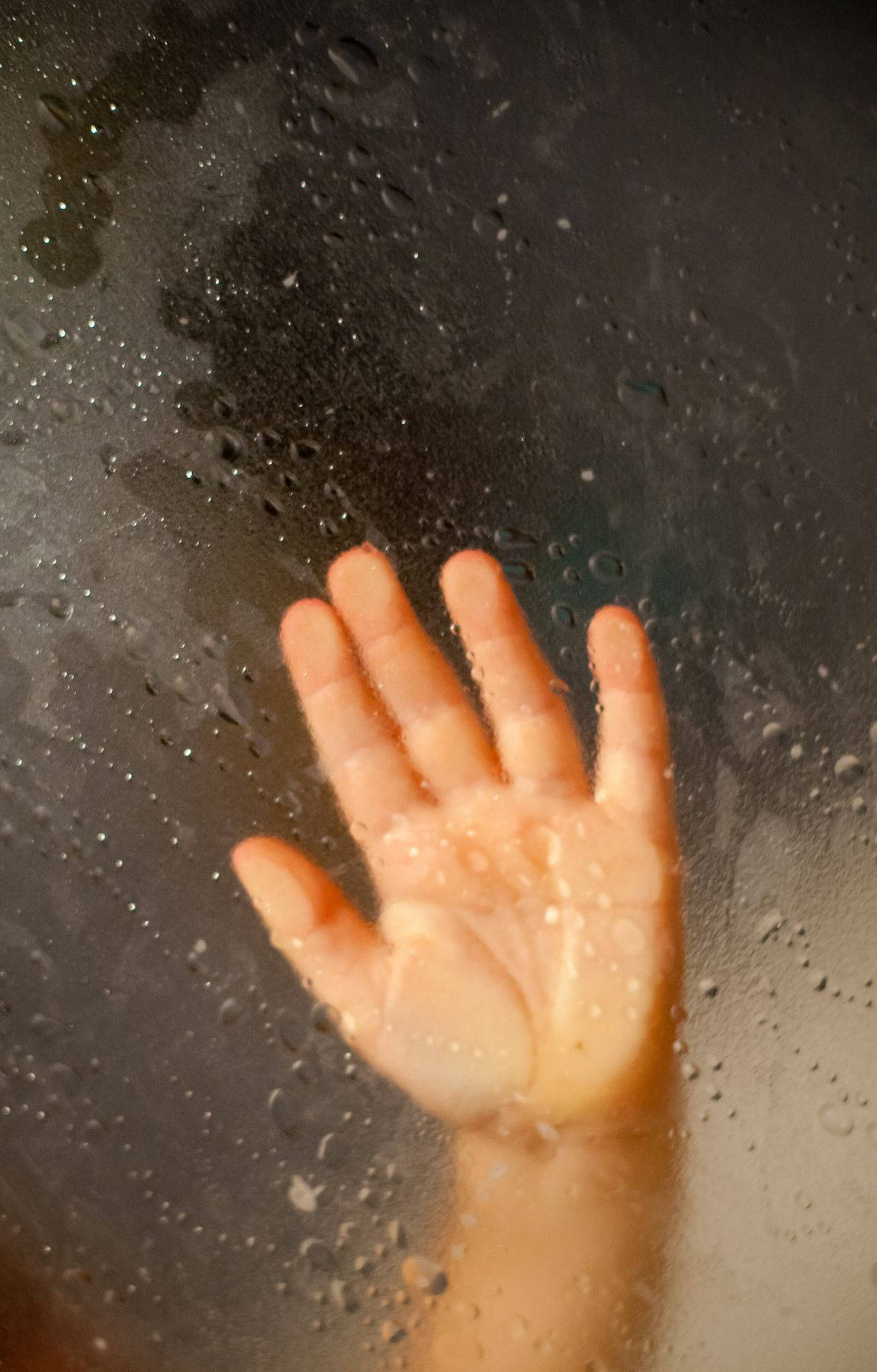 Baby Hand On A Wet Glass Background