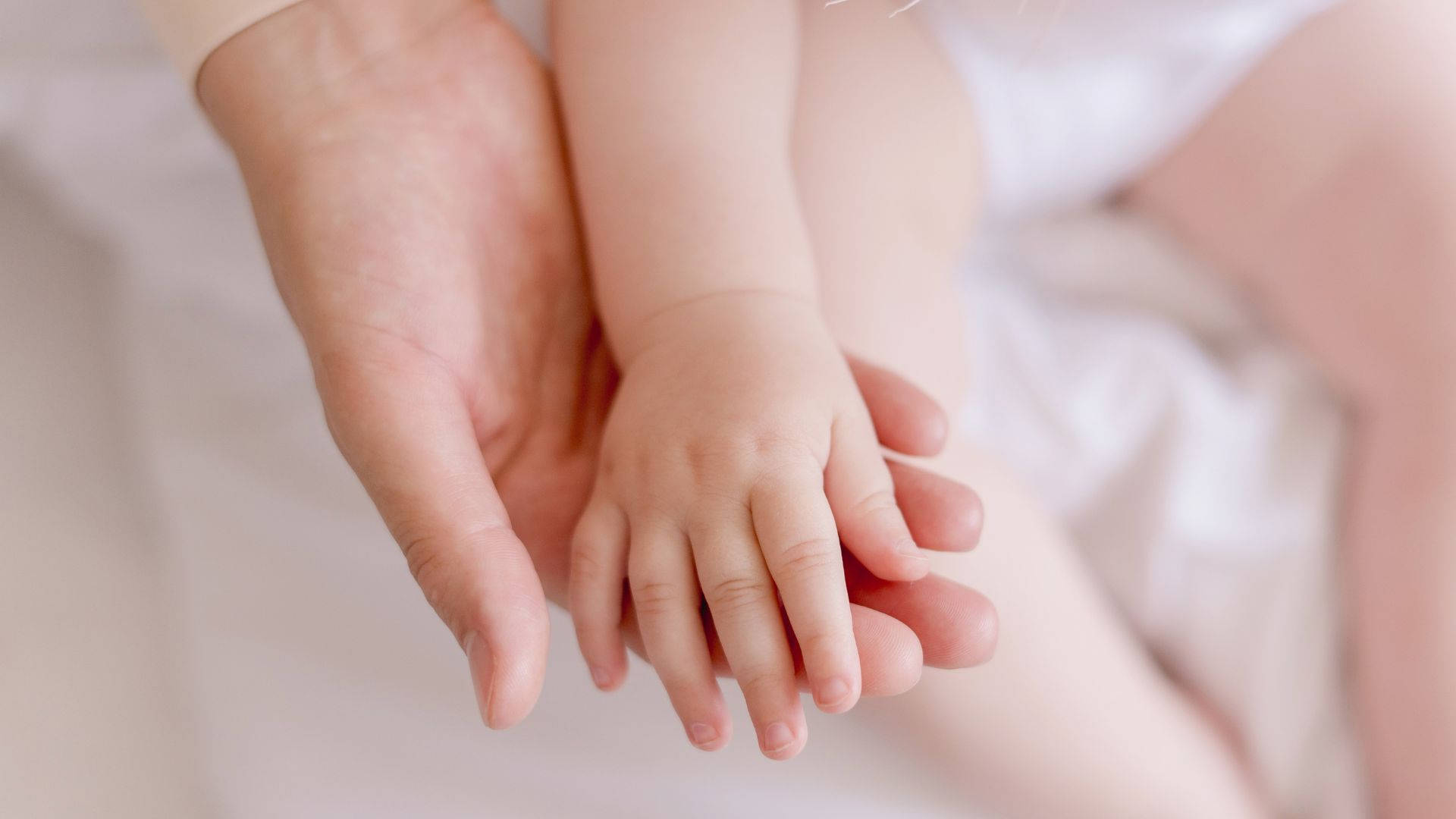 Baby Hand Resting On Mother's Hand Background