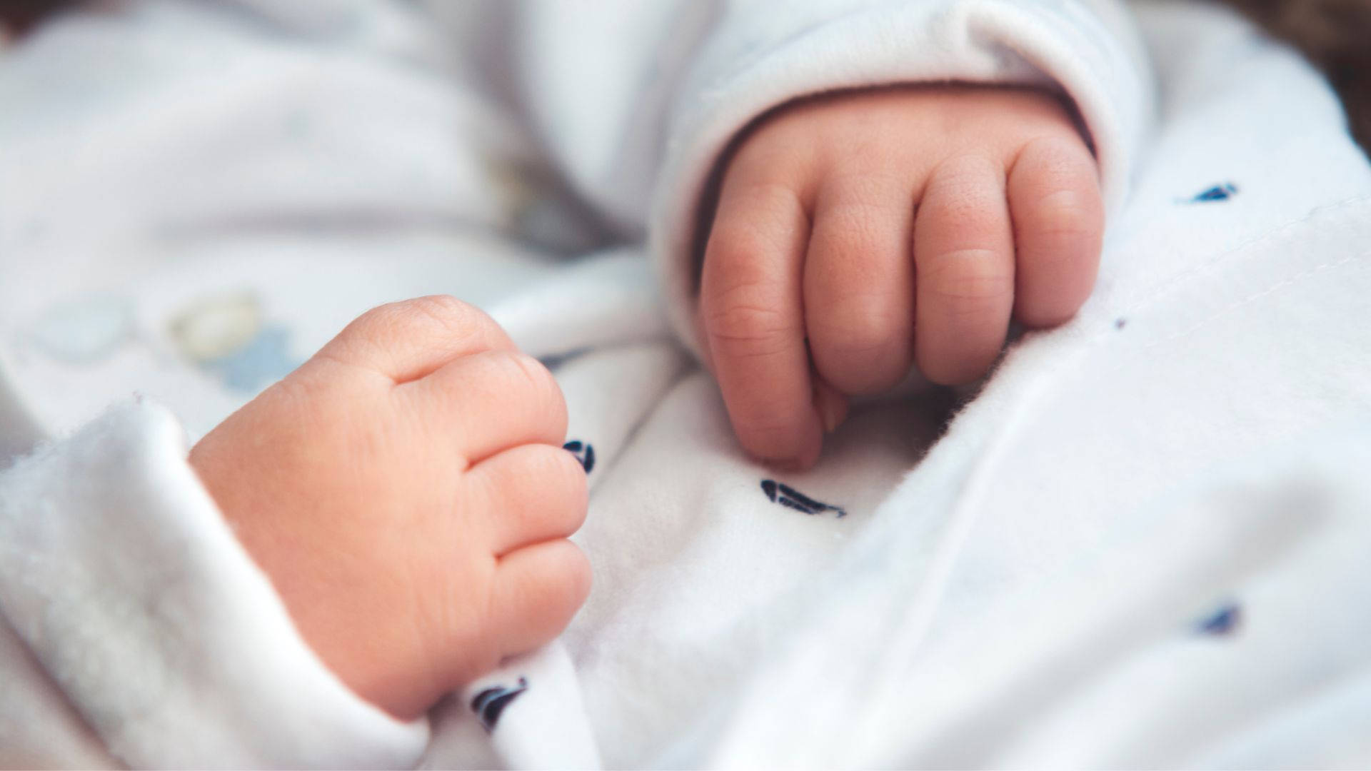 Baby Hands Wearing White Outfit Background