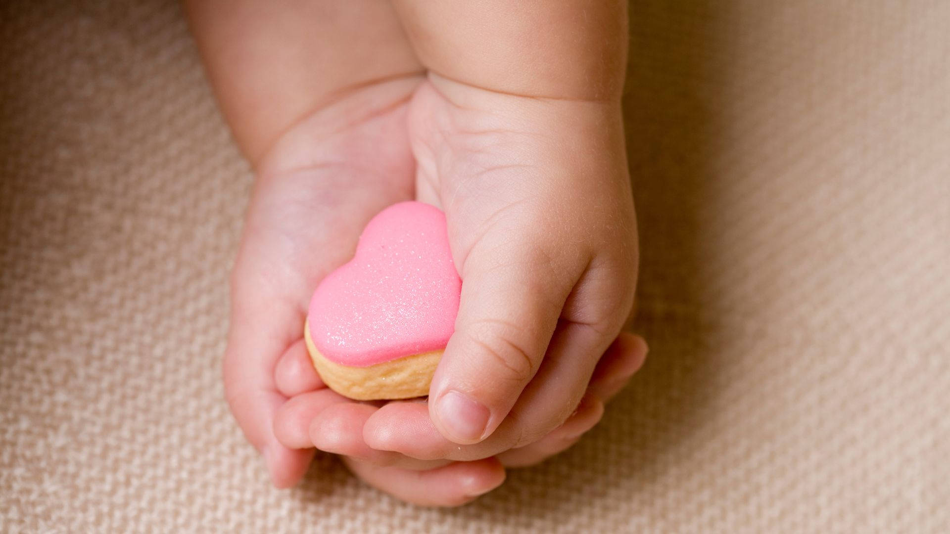 Baby Hands With A Pink Heart Background