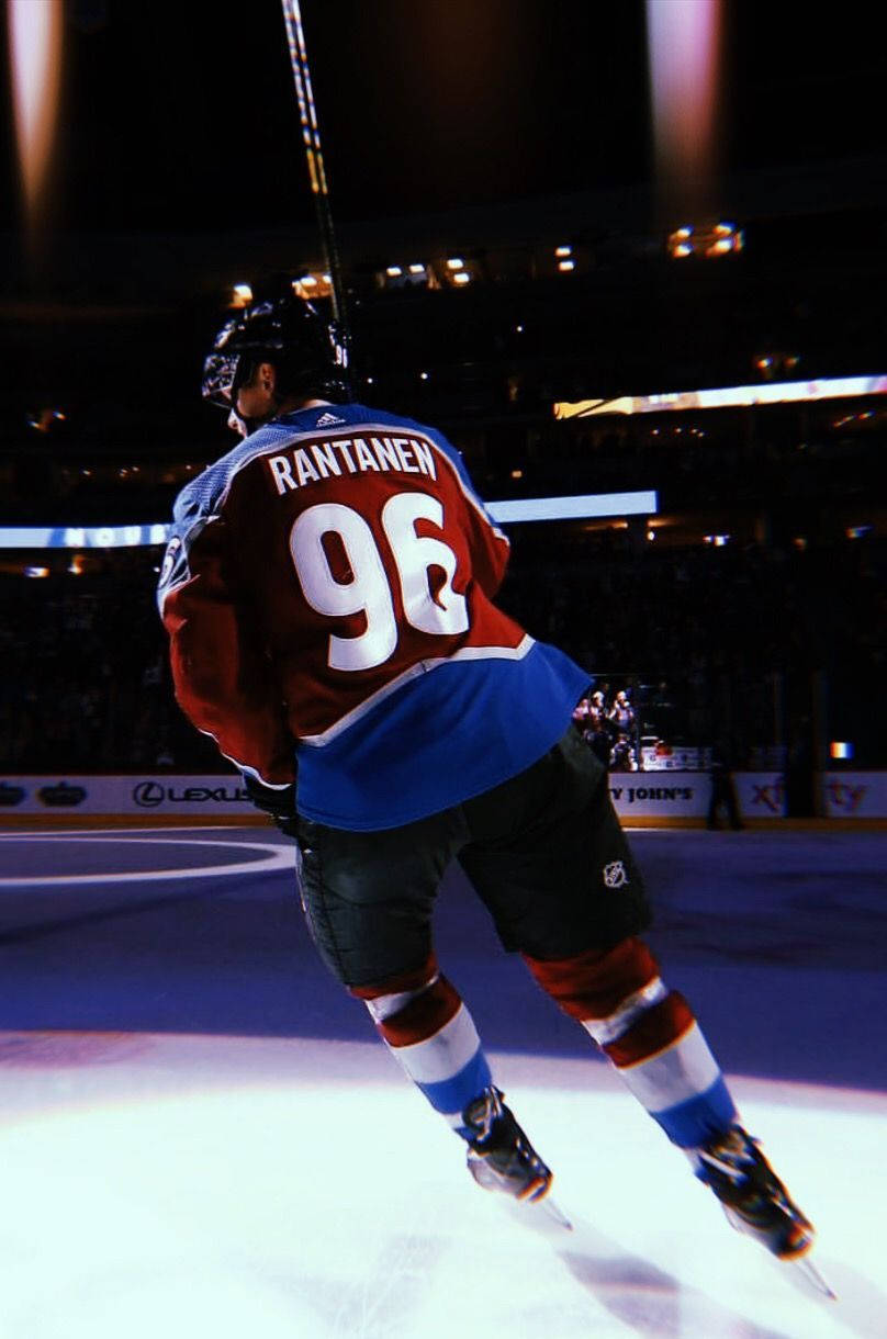 Back Shot Of Mikko Rantanen Leaning To The Left Under The Spotlight Background