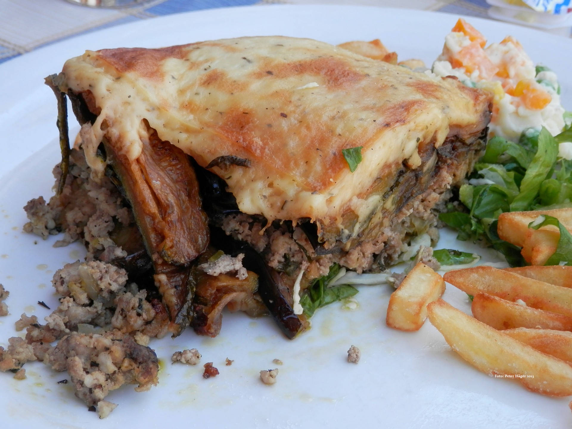 Baked Moussaka With Fries On A Plate Background