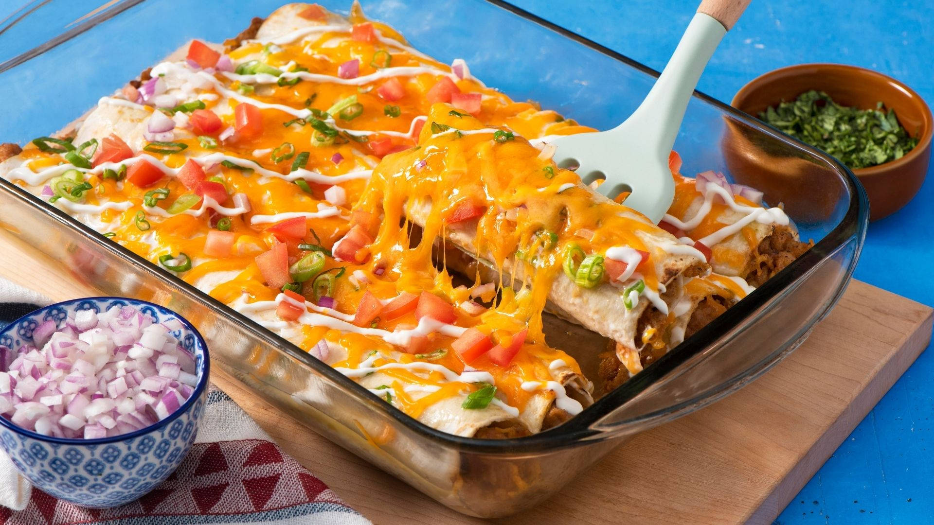 Baked Tray Of Cheesy Enchiladas With Onions Background