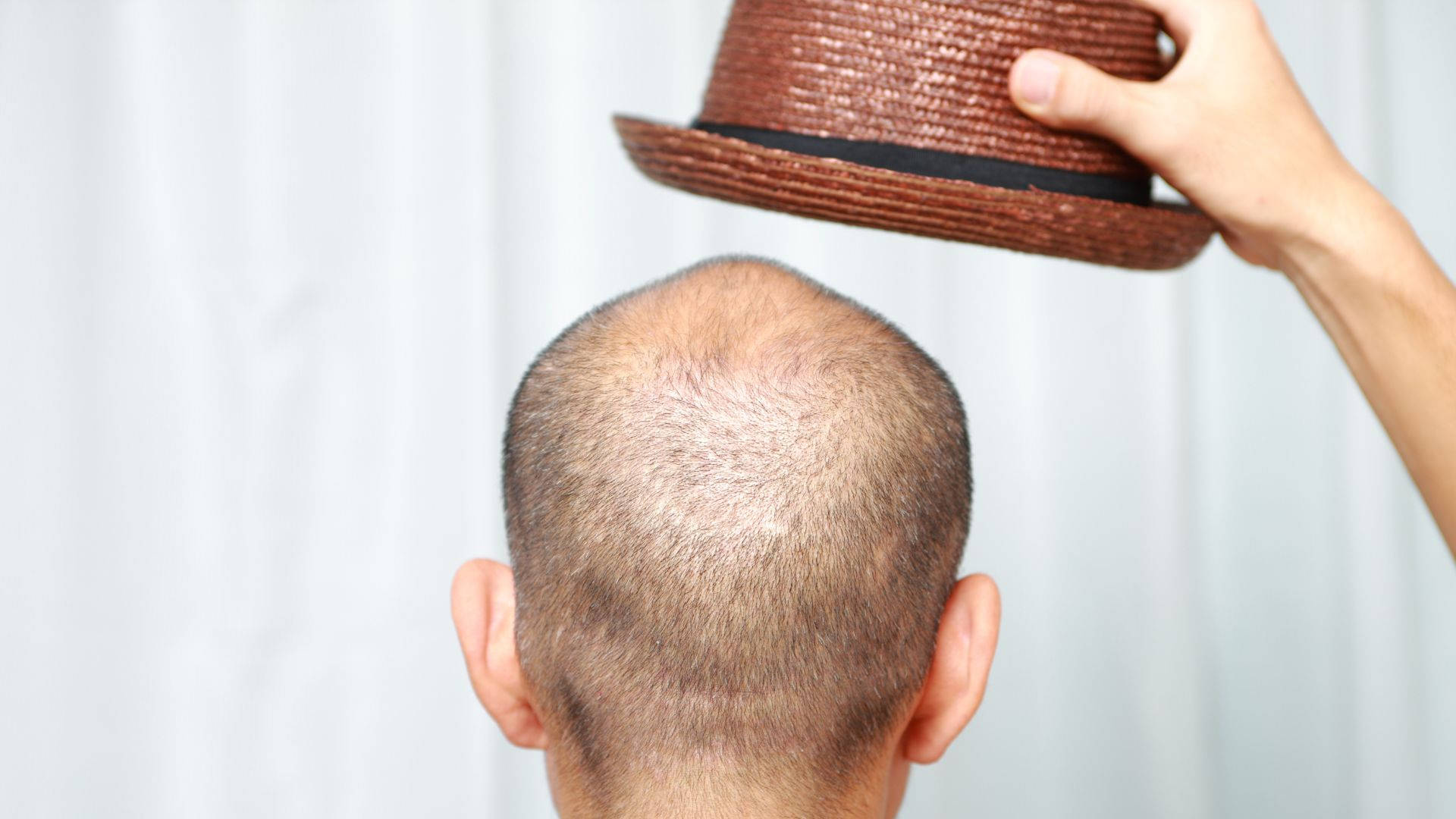 Bald Man Holding A Brown Hat Background