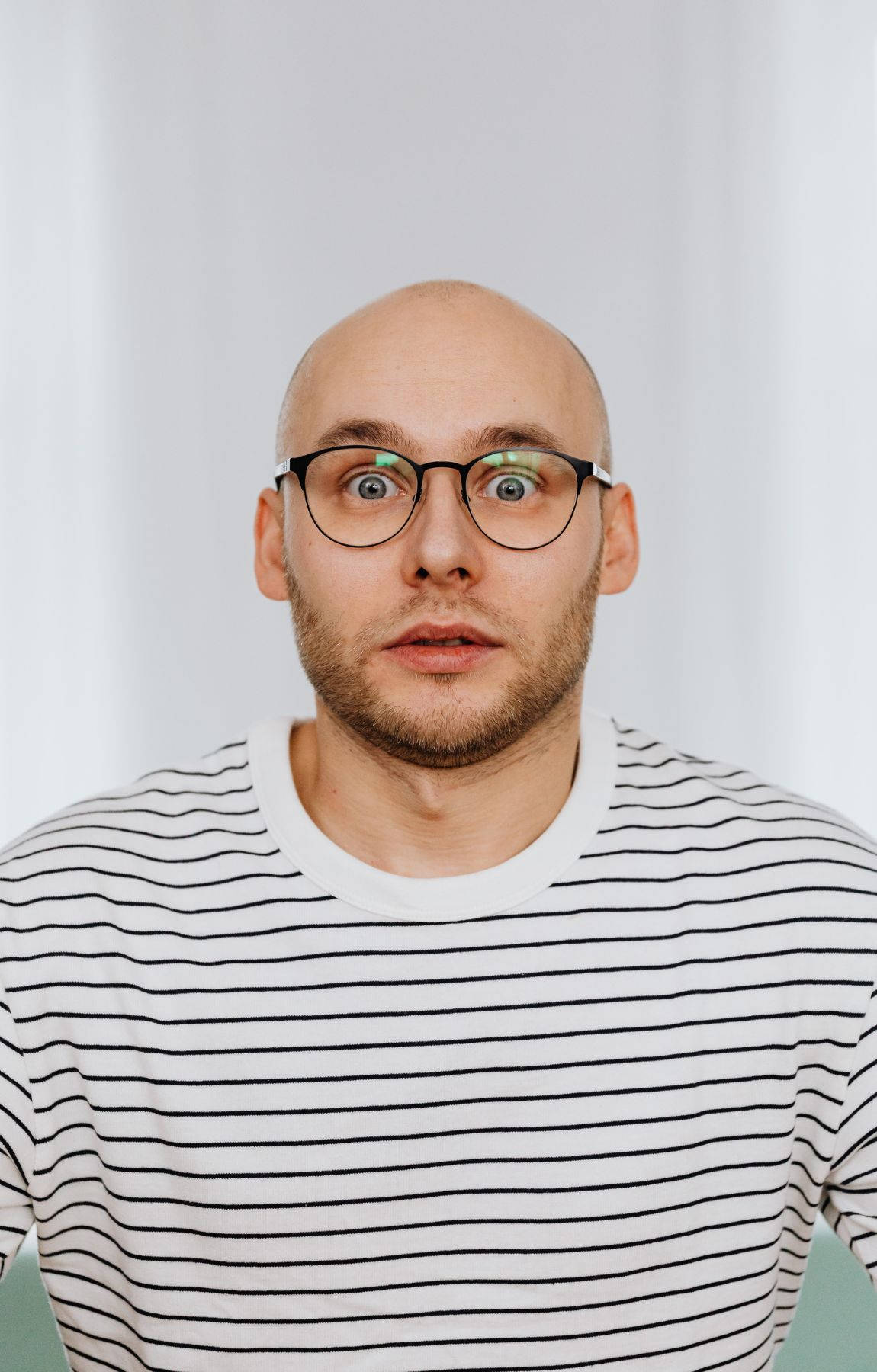 Bald Man With Wide Eyes Background