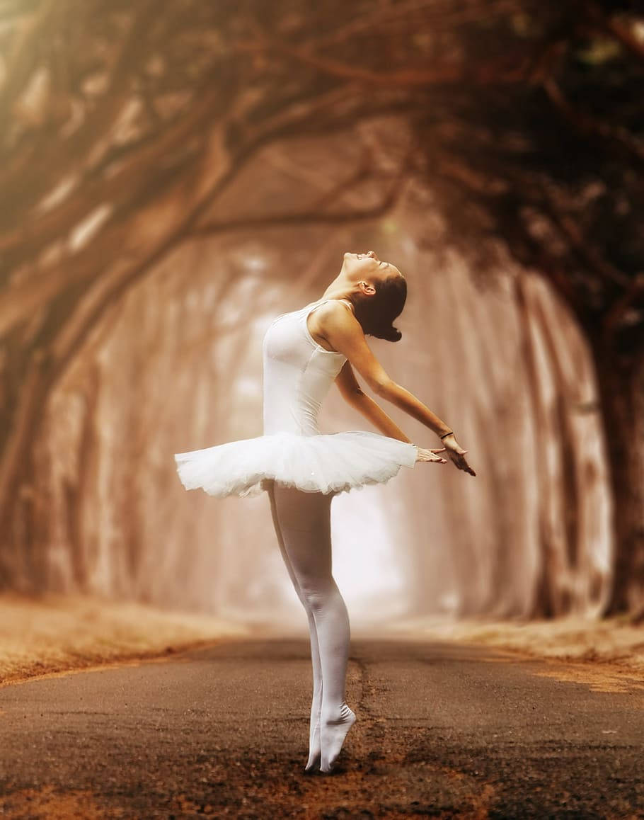 Ballet Dancer Surrounded By Trees Background