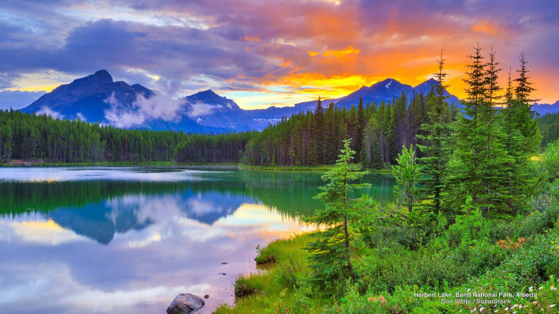 Banff National Park Orange Sky And Reflective River Background