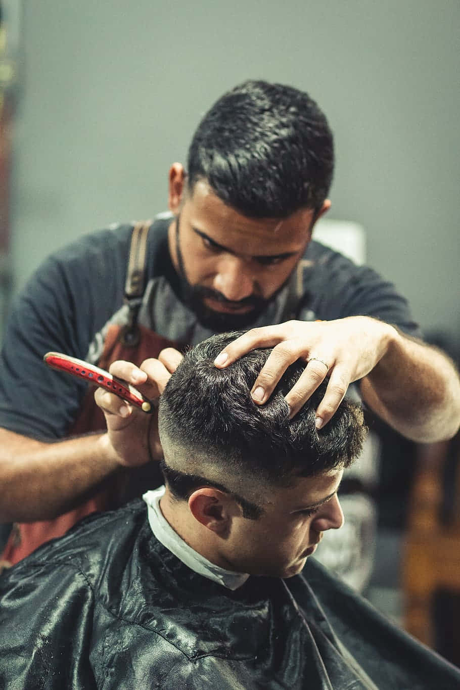 Barber Holding The Head While Cutting The Hair Background