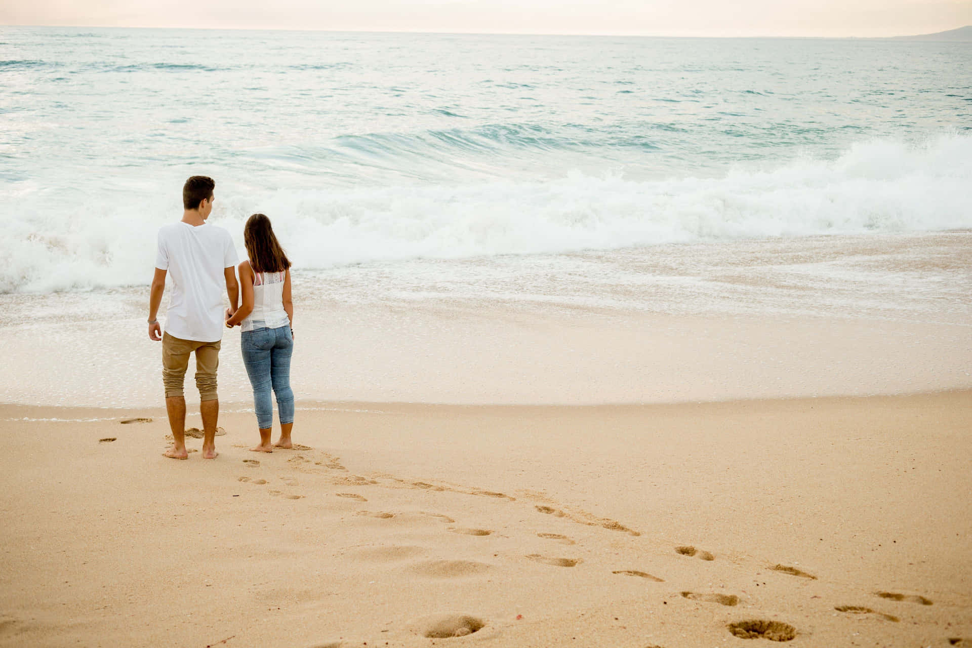 Barefoot Couple At Beach Waves Background