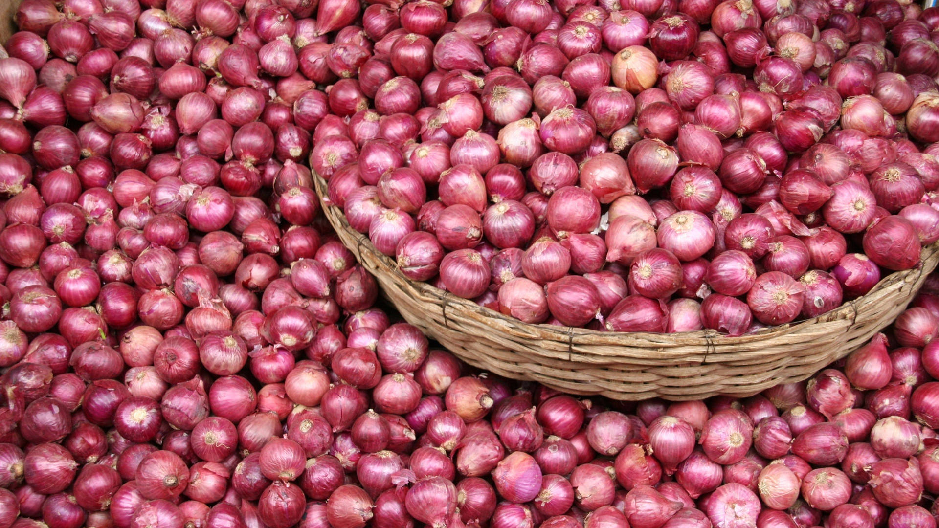 Basket With Harvested Stock Of Red Onions Background