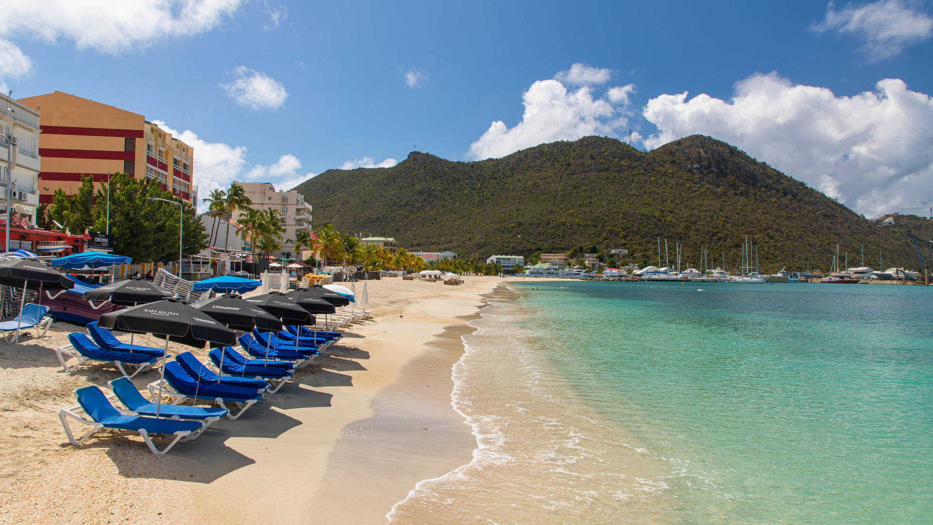 Beach Chairs In Sint Maarten's Shoreline Background